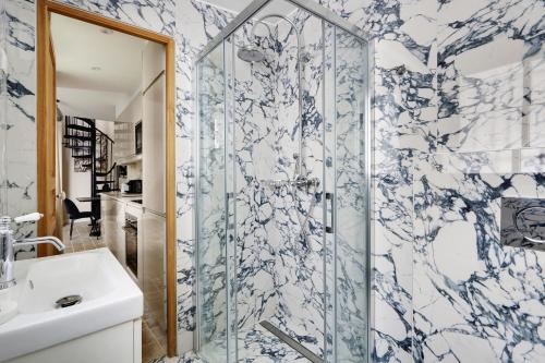 une salle de bain avec douche et lavabo dans l'établissement Pick A Flat's Apartment in Monrmartre - Rue Lepic, à Paris