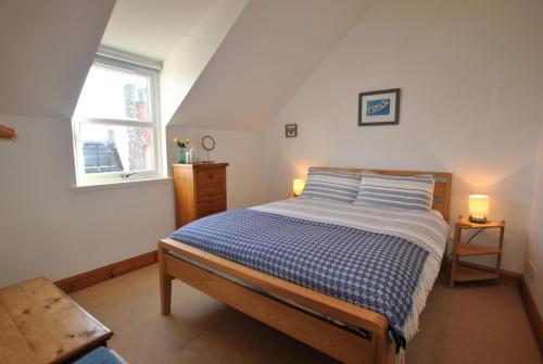 ein Schlafzimmer mit einem Bett und einem Fenster in der Unterkunft 2a Rose St- cosy coastal cottage Fife in Saint Monance