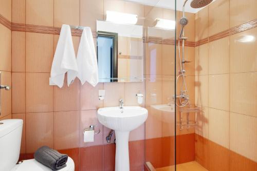 Un baño con lavabo, inodoro y ducha. en Villa prolithia 1, en Vlikhón