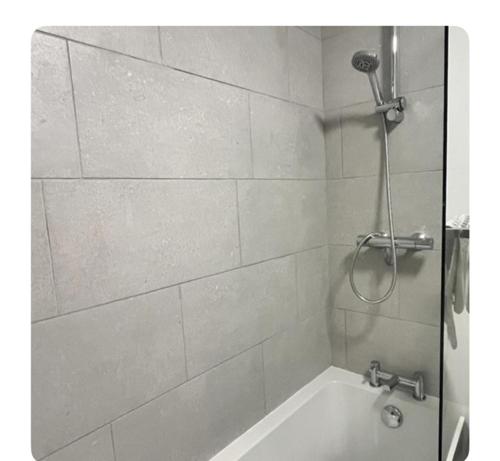 a bathroom with a shower and a bath tub at The Hideout in Trearddur