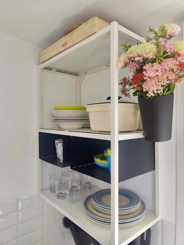 a white cabinet with plates and flowers in it at Buena Vista in Alhaurín de la Torre