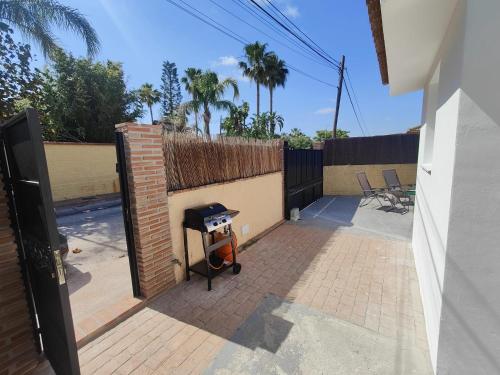 a backyard with a brick wall and a grill at Buena Vista in Alhaurín de la Torre