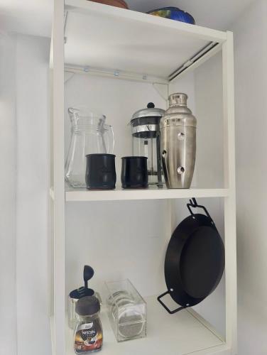 a white pantry shelf with various items on it at Buena Vista in Alhaurín de la Torre