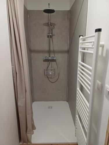 ein kleiner Raum mit einem weißen Kühlschrank und einem Kronleuchter in der Unterkunft La Cabane des 2 Sœurs (chalet 4-6 personnes) in Les Ougiers