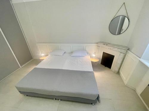 - une chambre avec 2 lits, un miroir et une cheminée dans l'établissement La Brise by Connexion, à Cannes