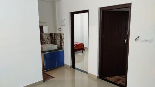 einen Flur mit einem Spiegel und einer Tür in einem Zimmer in der Unterkunft Akbar Cottages in Anachal