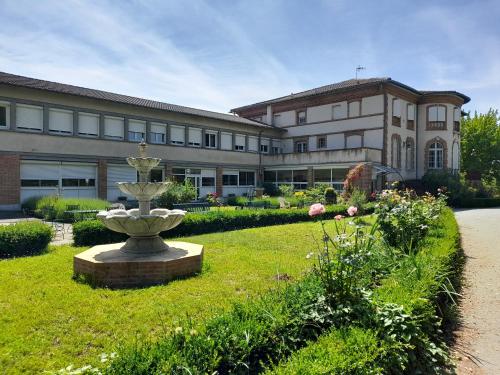 a large building with a fountain in the middle of a yard at Centre Louis Ormières in Montauban