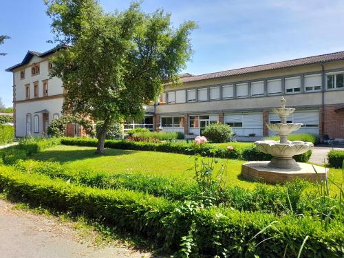 a building with a fountain in the middle of a yard at Centre Louis Ormières in Montauban