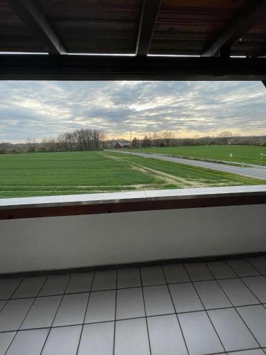 a view of a field from a train station window at Großzügige Ferienwohnung für bis zu 4 Personen mit Balkon in Capelle