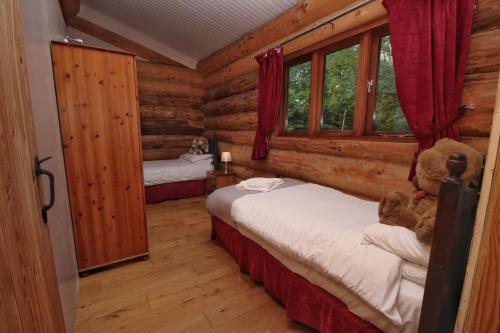 a bedroom with two beds in a log cabin at Log Cabin, Easter Hall Park in Petrockstow