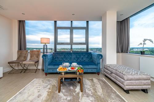 a living room with a blue couch and a table at Heathrow Family Apartments in Sunbury Common