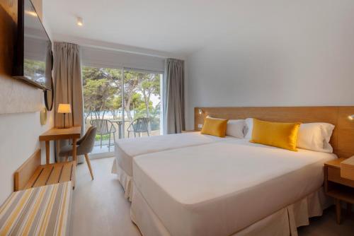 ein Hotelzimmer mit einem großen Bett und einem Fenster in der Unterkunft whala!isabela in Santa Ponsa