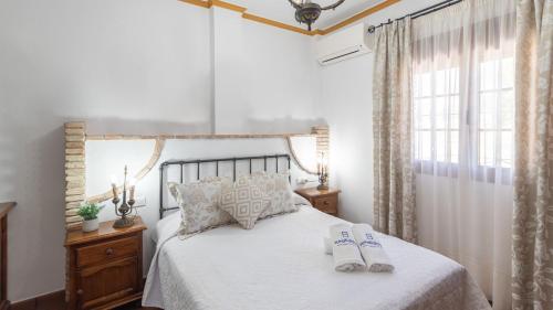 a bedroom with a bed with two slippers on it at Casa Tere Antequera - La Higuera by Ruralidays in Antequera