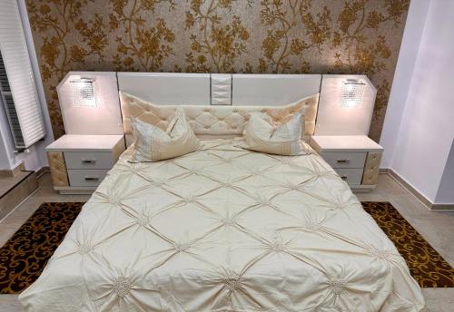 Un dormitorio con una gran cama blanca con almohadas. en NEW Burgeois Berindey Apartment - Universitate, en Bucarest