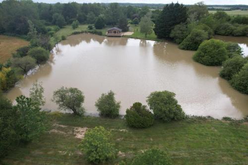 an aerial view of a river with a house in it at Un étang idéal pour la famille in Moussac-sur-Vienne