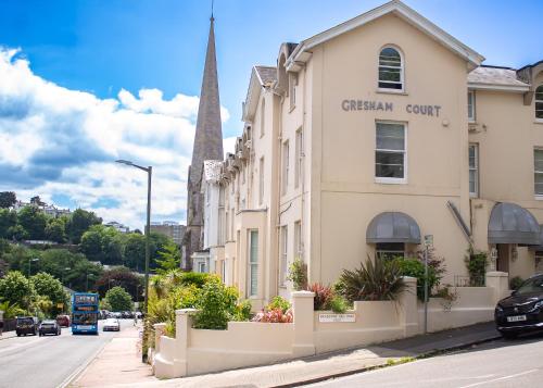 a building on the side of a street with a church at Gresham Court in Torquay