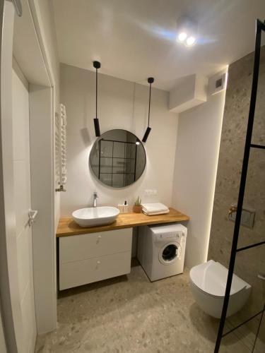 un baño con lavabo y espejo en TOMALE-AMT Apartamenty Kasprowicza Kołobrzeg - basen, jacuzzi, sauna, siłownia w cenie apartamentu, en Kołobrzeg