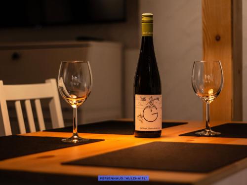 a bottle of wine sitting on a table with two wine glasses at Ferienhäuser Seiffen in Seiffen