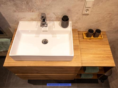 a bathroom sink with two cups on a wooden counter at Ferienhäuser Seiffen in Seiffen