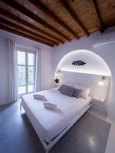 a white bedroom with a large white bed in a room at Mykonos Summer House in Mikonos