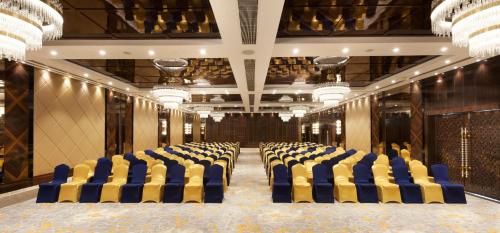 a room with blue and yellow chairs in a building at Hotel Cenneys Gateway in Salem