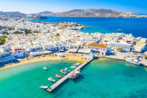 ミコノス・シティにあるMykonos Summer Houseの海上ボートが浮かぶビーチの空中ビュー