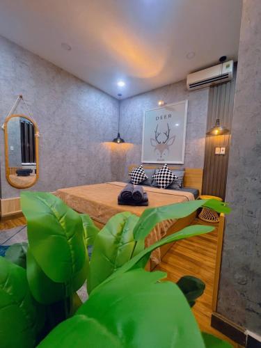 a room with a bed and a plant in it at MIS HOSTEL Cần Thơ in Can Tho
