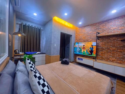 a room with a large bed and a brick wall at MIS HOSTEL Cần Thơ in Can Tho