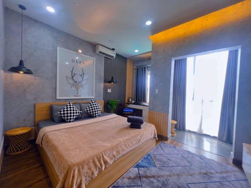 a bedroom with a large bed and a large window at MIS HOSTEL Cần Thơ in Can Tho