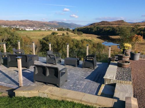 a patio with a bunch of chairs and a fireplace at Misty Isle Apartments Ltd - Maol View in Kyleakin