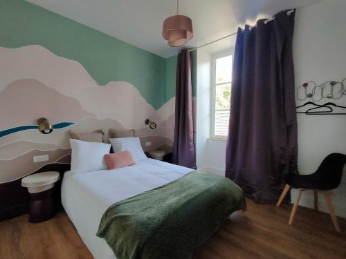 a bedroom with a bed with a surfboard on the wall at Les Epingliers - Le Clos Lacam, centre ville, dog friendly in Gourdon-en-quercy