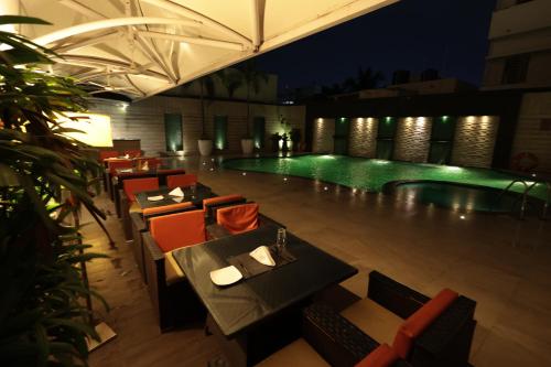 a swimming pool with tables and chairs next to a restaurant at Hotel Cenneys Gateway in Salem