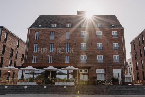 un gran edificio de ladrillo con sombrillas delante en Südspeicher, en Kappeln