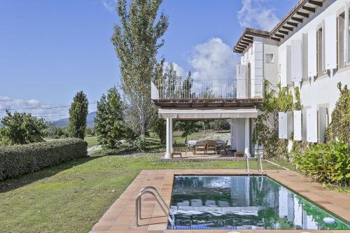 a house with a swimming pool in the yard at Casa de lujo con piscina, pádel y BBQ in Candeleda