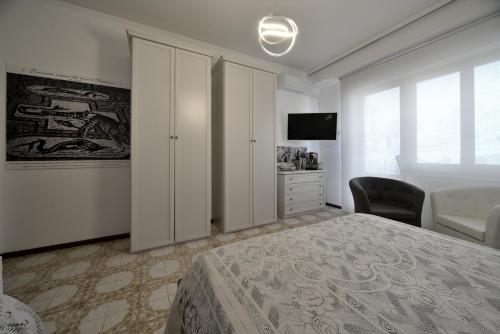 a bedroom with a bed and a chair and a television at WAST-HOST by MICHELANGELO in Vasto