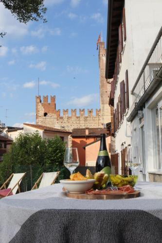 a table with a plate of food and a bottle and glass at Casa Clarita - in centro storico in Marostica