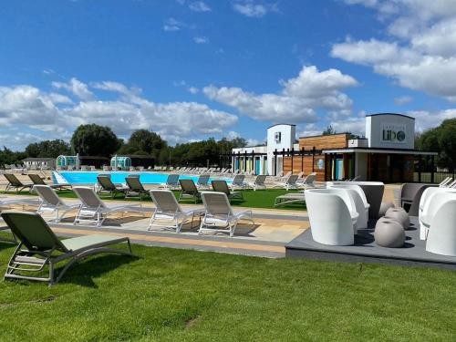 a row of lounge chairs sitting next to a pool at David's place at Tattershall lakes in Tattershall