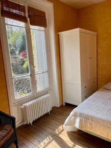 a bedroom with a bed and a large window at Cosy apartment in Paris area in Suresnes
