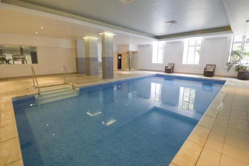 ein großer Pool in einem großen Gebäude in der Unterkunft Broome Park Hotel in Canterbury