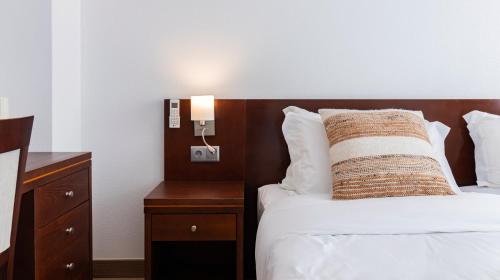 a hotel room with a bed with a pillow on it at Albergaria Quim Barreiros in Vila Praia de Âncora