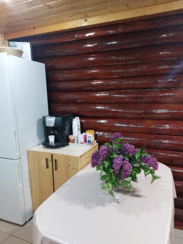 a table with a vase of purple flowers on it at Cabana Stînă - Duplex Montan in Topliţa
