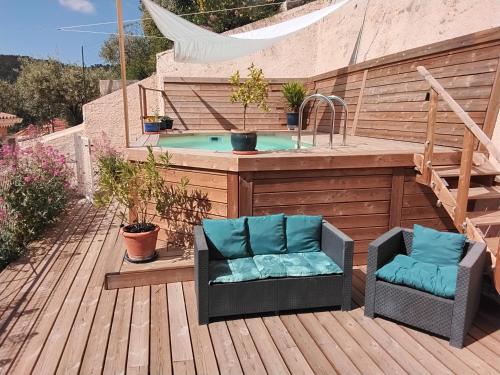 a patio with a hot tub and two chairs on a deck at Villabellevie Bargemon Var in Bargemon
