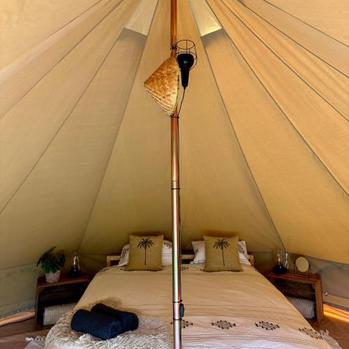 a room with a tent with two beds in it at Wereldse Bell Tenten met alpaca's in Paasloo