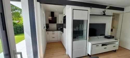 a kitchen with a white cabinet and a television at Bungalow 2243 in Tossens in Butjadingen