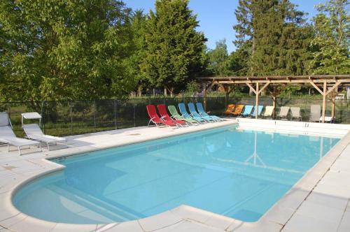 una piscina con 2 sillas y un grupo en Le Mas d'en Haut, en Lussat