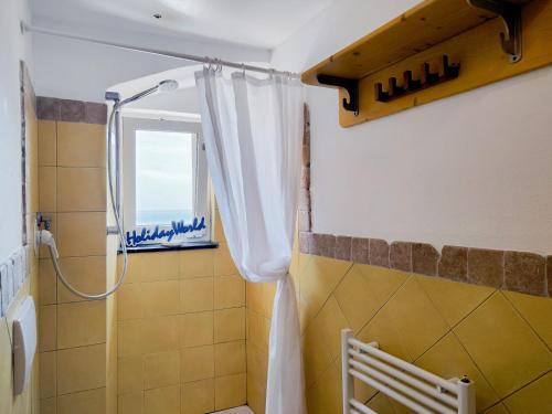 baño con cortina de ducha y ventana en Fuori Rotta House by Holiday World, en Génova