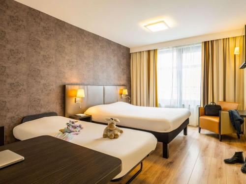 una habitación de hotel con 2 camas y una silla en ibis Styles Hotel Brussels Centre Stéphanie, en Bruselas