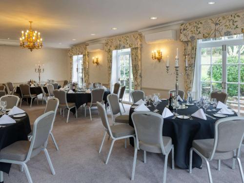 a room with tables and chairs in a room at Sunday Box Hill Burford Bridge Hotel in Dorking