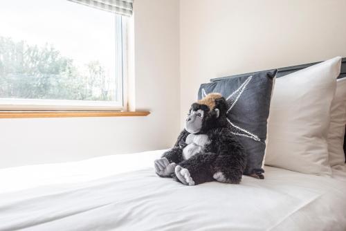 a stuffed monkey sitting on top of a bed at 5 Toller Close, Orford in Orford