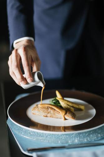 a person holding a spoon over a plate of food at Hilton Molino Stucky Venice in Venice